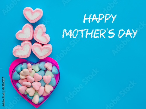 mother's day concept. Marshmallow in a heart frame with Happy mother's day text on blue sky background