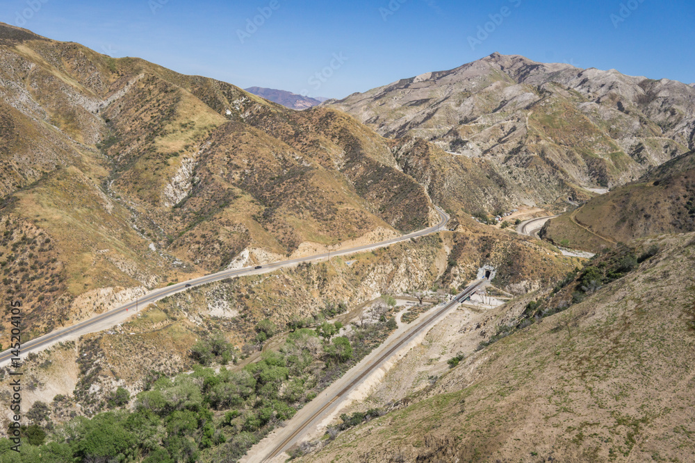 Mountain road and train tracks through the foothills of the San Gabriel mountains in Los Angeles county.