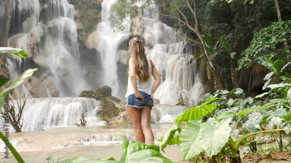 Girl standing and admire amazing waterfall in Luang Prabang, Laos Girl standing and admire amazing waterfall in Luang Prabang, Laos
