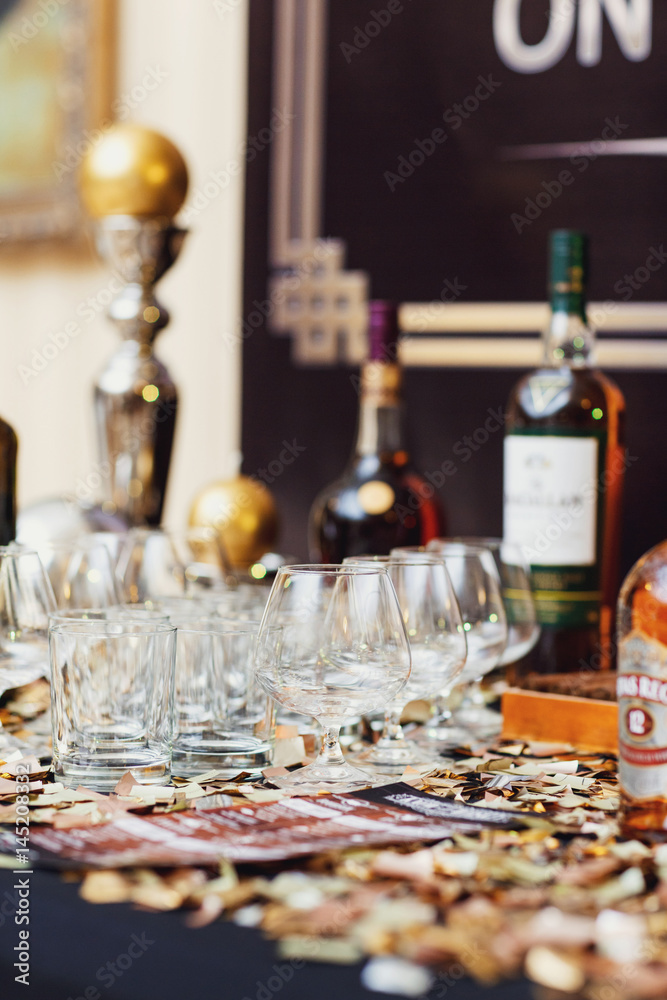 Empty glasses stand on black table with whisky