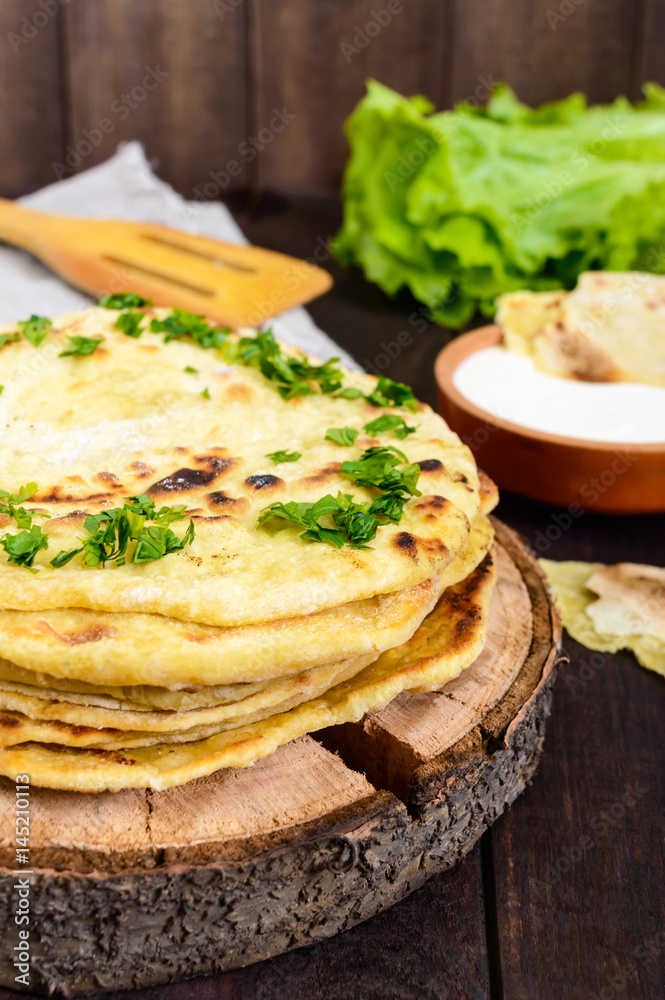Thin flatbread - traditional Asian bread on a dark wooden background. Vertical view Thin flatbread - traditional Asian bread on a dark wooden background. Vertical view