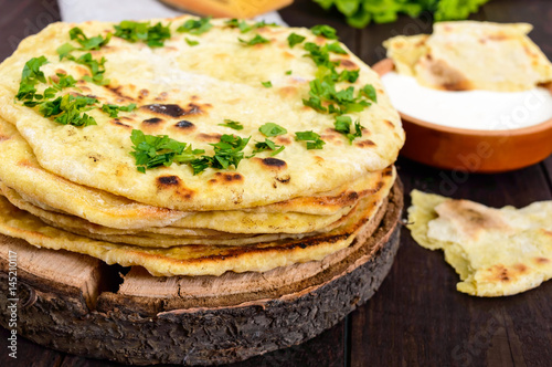 Thin flatbread - traditional Asian bread on a dark wooden background.