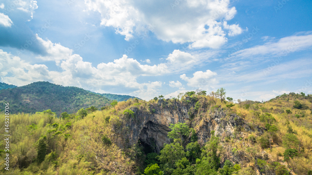 aerial photography above amazing cave. Tham Than Lod Yai is the big cave and have one hole on the top of the cave. it is a short cave there have waterfall pass inside through to another cave
