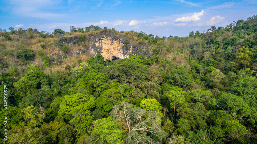 aerial photography above amazing cave. Tham Than Lod Yai is the big cave and have one hole on the top of the cave. it is a short cave there have waterfall pass inside through to another cave