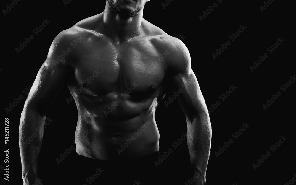 Horizontal cropped black and white studio shot of a muscular sexy torso of an athletic man posing shirtless on black background copyspace fitness strength athletics power sports bodybuilding concept. Horizontal cropped black and white studio shot of a muscular sexy torso of an athletic man posing shirtless on black background copyspace fitness strength athletics power sports bodybuilding concept.