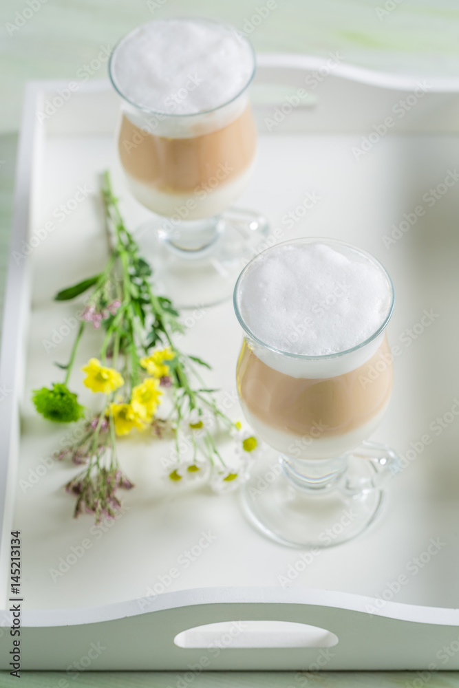 Iced coffee with whipped cream and chocolate on white table