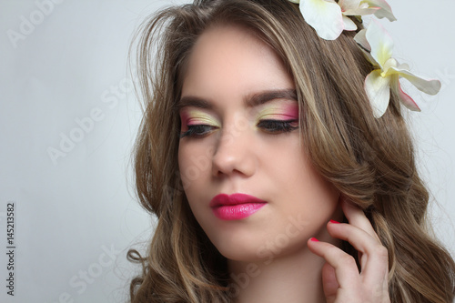 Portrait of a young girl with a beautiful bright make-up on a neutral background