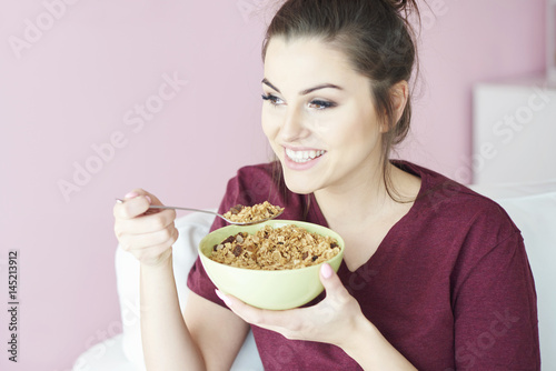 Young woman having cereal with milk for breakfast