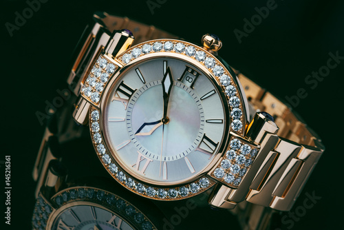 Elegant golden with diamond men’s watch against dark background photo