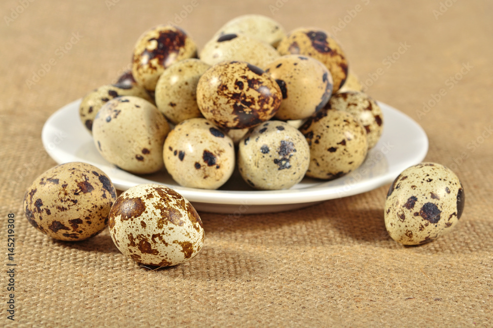 Quail eggs in a white bowl in a sacking Quail eggs in a white bowl in a sacking