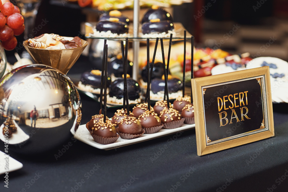 Wooden frame with lettering 'Desert bar' stands before table with chocolate