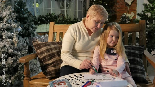 Grandma Drawing With Little Girl Telling Story Playing Together New Year Interior Lights Cosy Room Soft Light Traditional Attributes of Christmas Eve