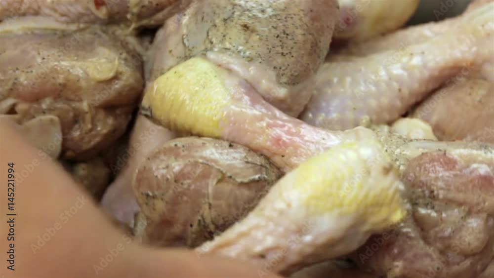 Closeup of woman's hands marinating chicken legs for barbecue Closeup of woman's hands marinating chicken legs for barbecue