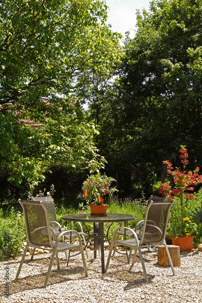 Sitzgruppe mit Tisch in einem blühenden Garten