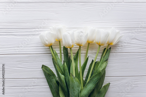 Mother s Day . white tulips on white wooden background