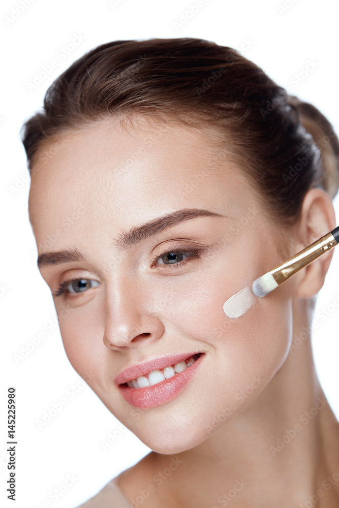 Beauty. Beautiful Woman Applying Foundation With Cosmetic Brush