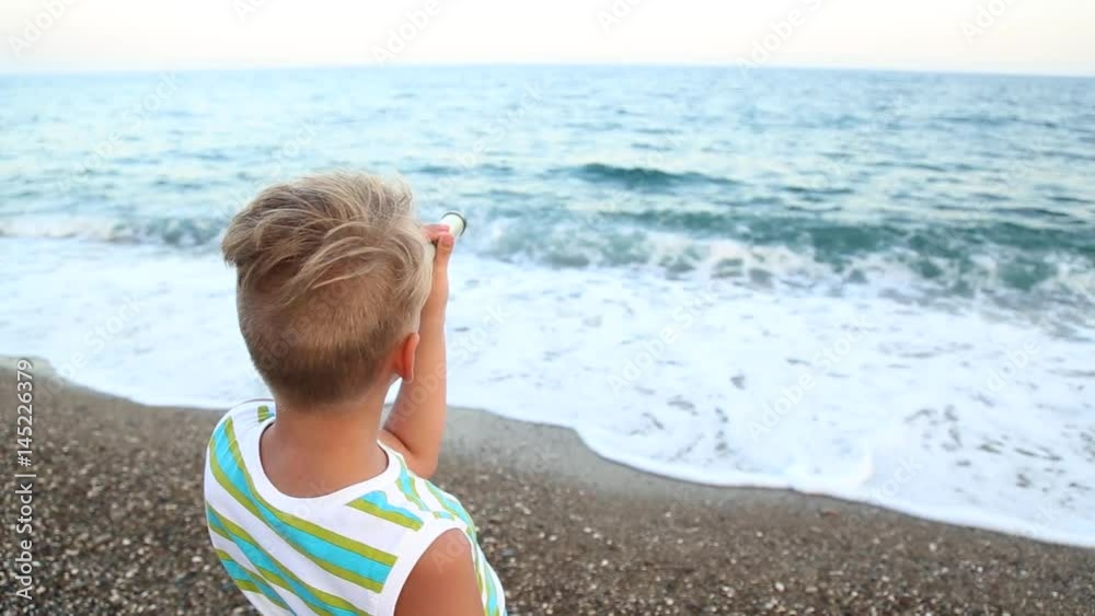 Funny little boy looking through telescope at beautiful sea waves. 9 years old child enjoying nature on warm summer day. Real time video clip. Funny little boy looking through telescope at beautiful sea waves. 9 years old child enjoying nature on warm summer day. Real time video clip.