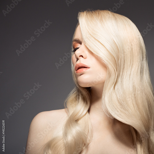 Portrait Of Beautiful Young Blond Woman With Long Wavy Hair.
