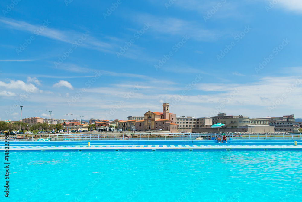 An outdoor pool is on the background of the European urban landscape