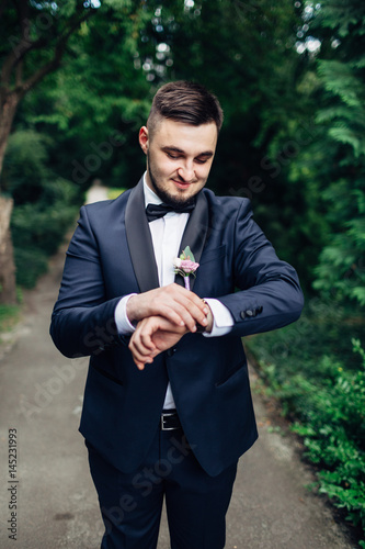 The handsome groom looking at watch