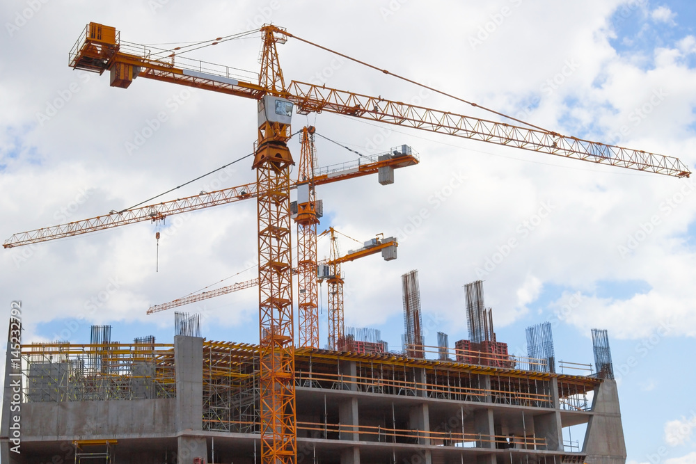 Building cranes and buildings on  background cloudy sky