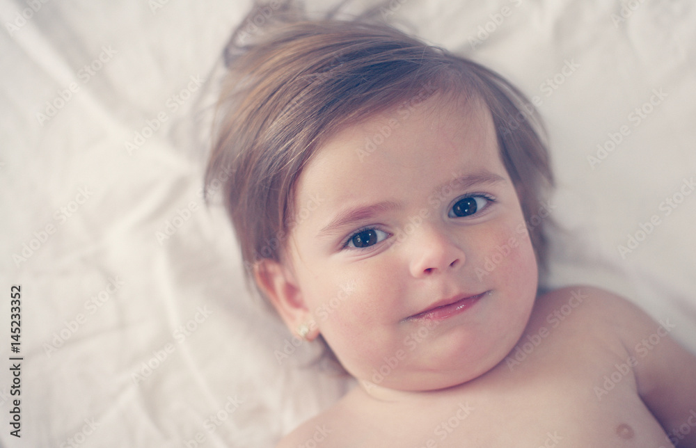 Smiling baby girl lying on the bed. Smiling baby girl lying on the bed.