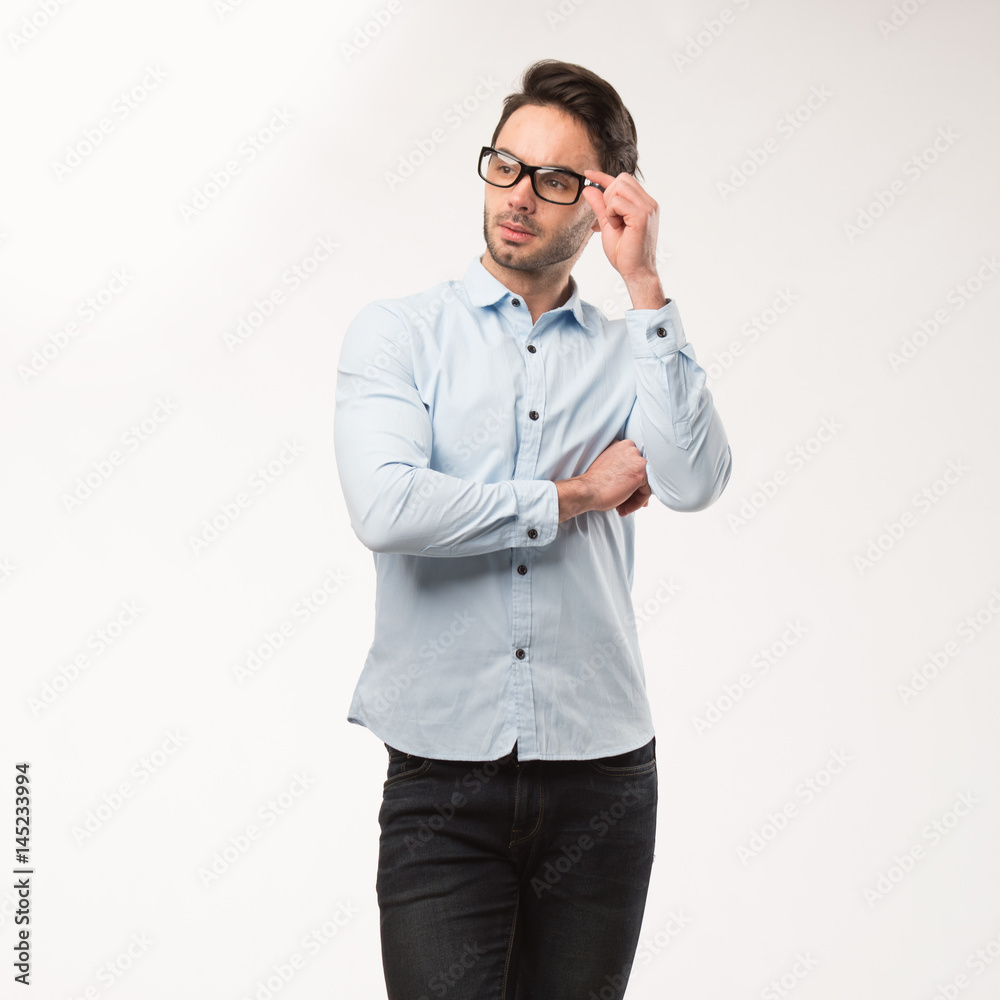 Young happy man showing presentation, pointing on placard over gray background Young happy man showing presentation, pointing on placard over gray background