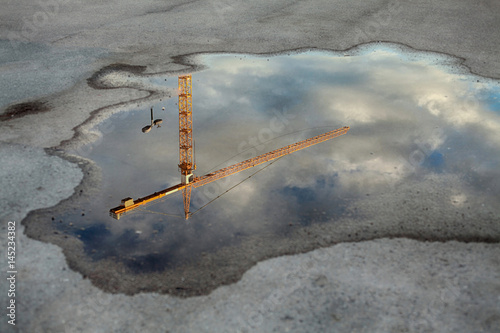 Crane tower reflection in the puddle