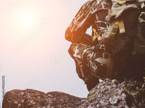 Soldier sitting relaxed on the top mountain.