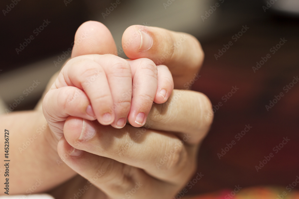 A newborn holding his mothers finger. A concept of love and security. A newborn holding his mothers finger. A concept of love and security.