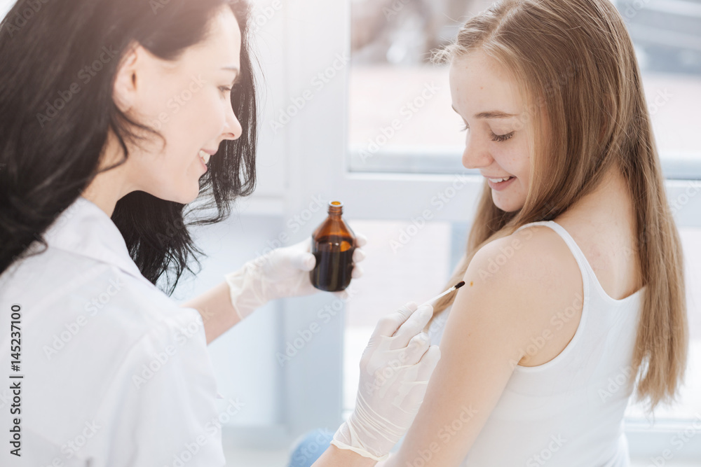 Upbeat practitioner using iodine for patient skin disinfection at work Upbeat practitioner using iodine for patient skin disinfection at work