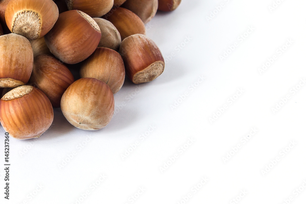 Pile of hazelnuts in a corner isolated on white Pile of hazelnuts in a corner isolated on white