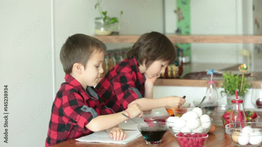 Two children, boys, coloring easter eggs at home Two children, boys, coloring easter eggs at home