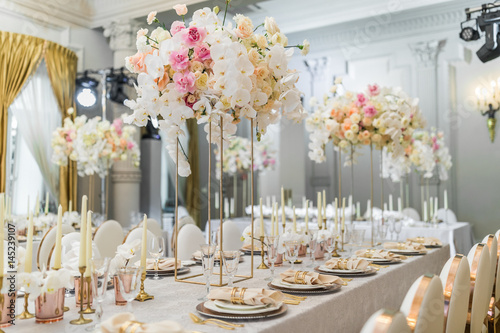 Chairs with round backs stand at dinner table with orchids