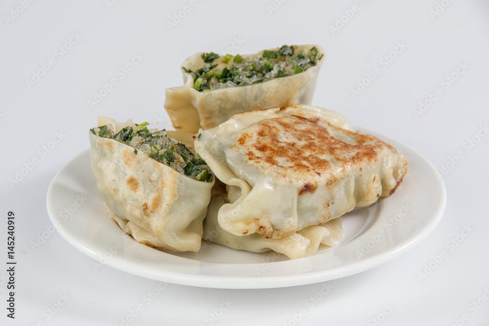 pan-fried leek dumplings on a plate isolated on white background
pan-fried leek dumplings on a plate isolated on white background