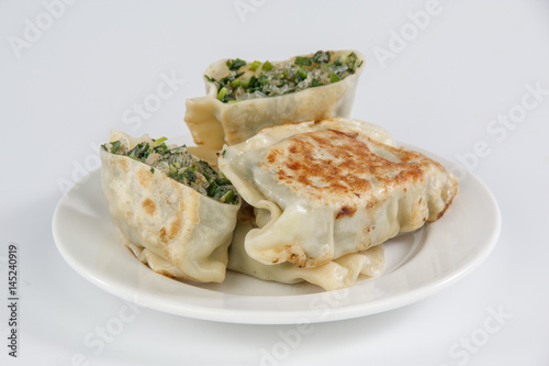 pan-fried leek dumplings on a plate isolated on white background 