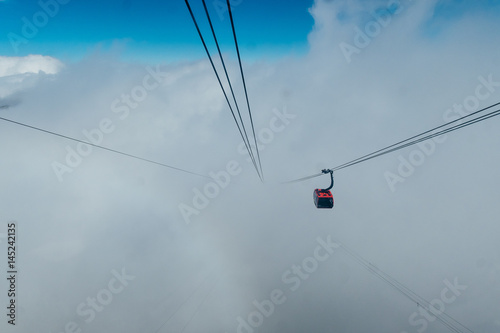 Elevator crosses white clouds