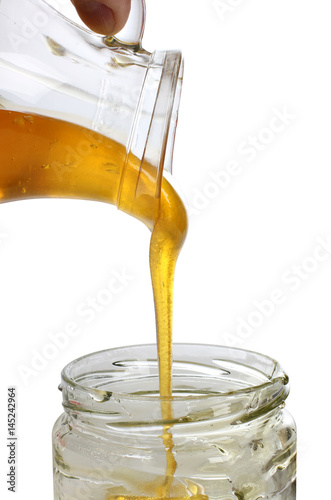 Glass jar with honey on a white background