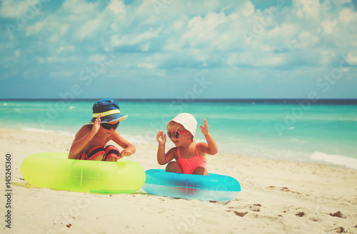 cute little boy and girl play on beach