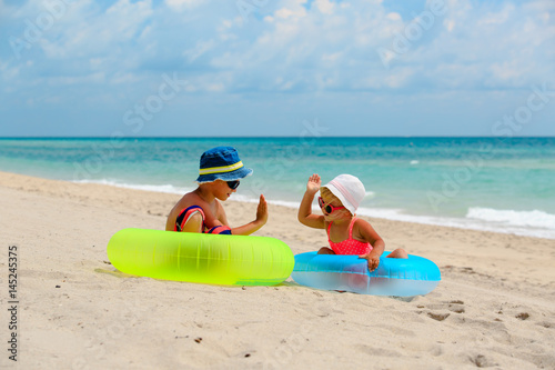 Fototapeta Naklejka Na Ścianę i Meble -  cute little boy and girl play on beach