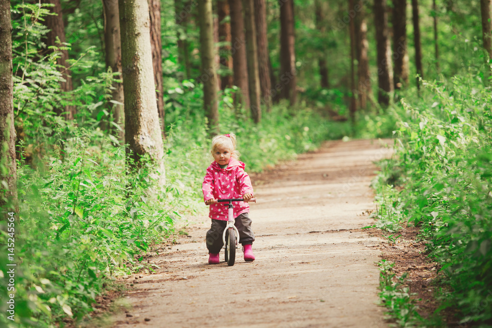 little girl riding bike in summer forest little girl riding bike in summer forest