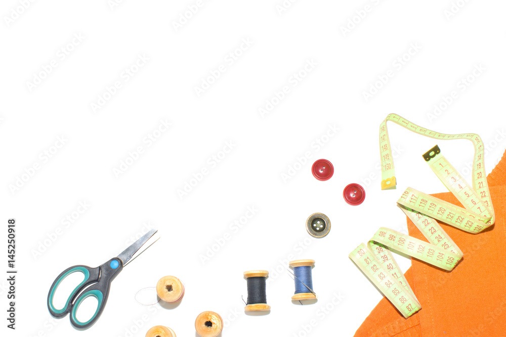 Coil with thread, scissors and ruler on a piece with a bright cloth, on ...