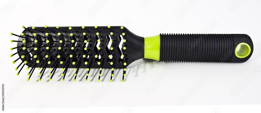 Fototapeta premium Isolated black hairbrush with bright green accents.