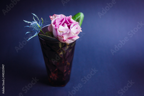 Fototapeta Naklejka Na Ścianę i Meble -  Dark violet glass with pink rose and blue cone