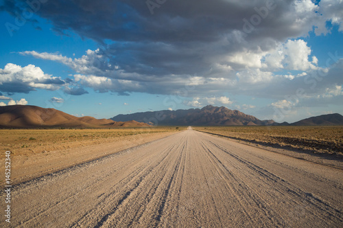 Scenic View of a Desert and Mountain Landscape with Clouds and Road near Solitaire, Namibia