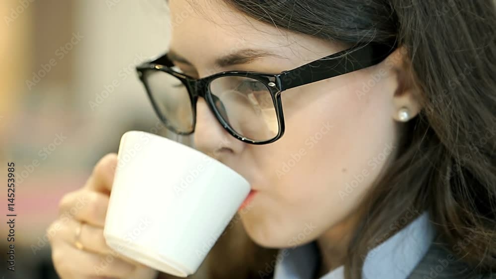 Businesswoman looks absorbed while drinking coffee and working, steadycam shot
Businesswoman looks absorbed while drinking coffee and working, steadycam shot