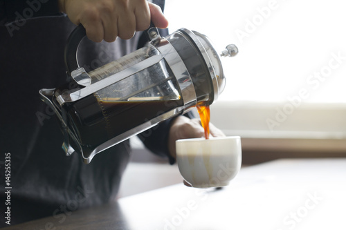 Pouring coffee from French press coffee maker
