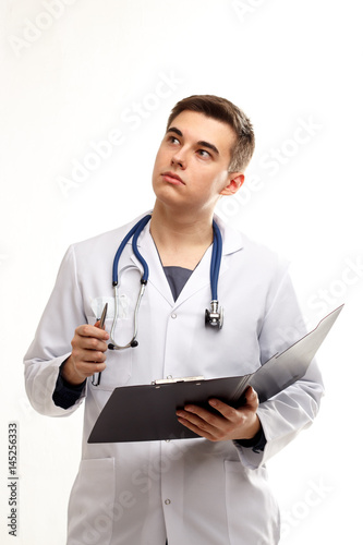 Young thinking doctor on a white background