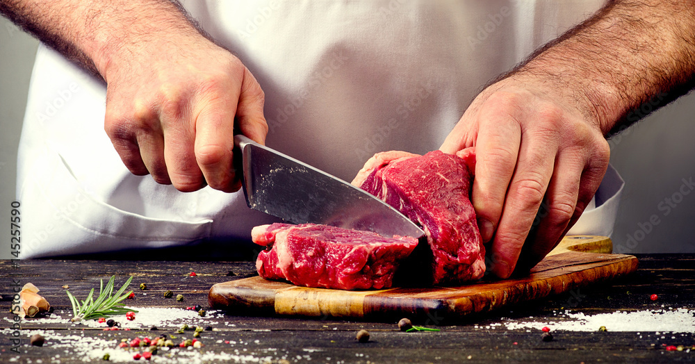 Man cutting beef meat - obrazy, fototapety, plakaty 