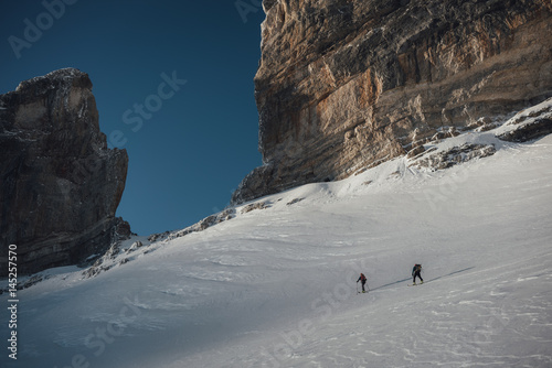 Ski mountaineers skinning up towards the pass